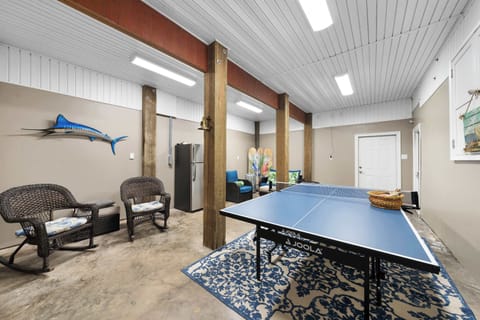 Fun meets comfort on the lower level—enjoy a game of ping pong, relax in plush chairs, and grab a drink from the fridge.