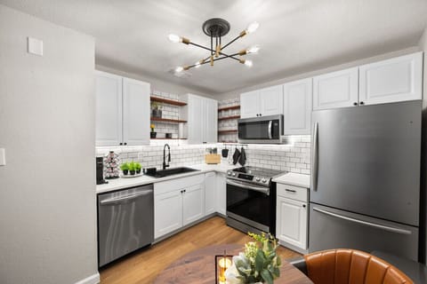 Fully stocked kitchen from dining area, showing all appliances, and coffee area
