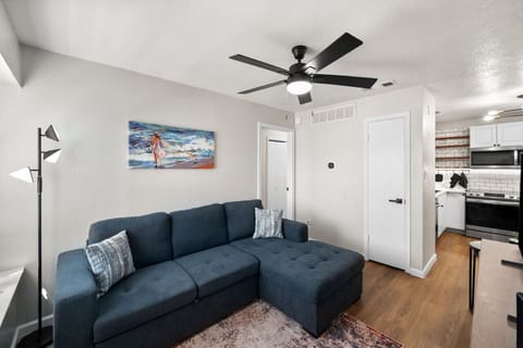 Living room with convertible full sized couch, Samsung TV, view toward bedroom and kitchen