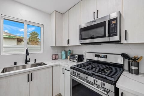 Modern kitchen w/ gas range, stainless appliances & clean white cabinetry for easy, everyday cooking.