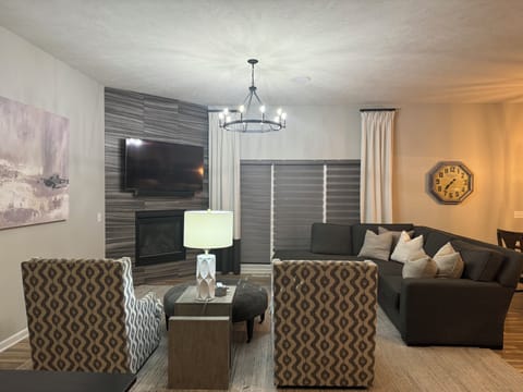 Living room with sofa, tv and two swivel chairs for conversation and tv viewing.