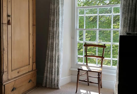 Chair next to a large window in Bedroom 1