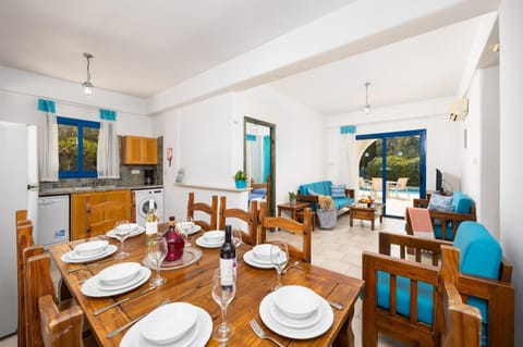 Open-plan living room with sofas, dining area, kitchen, A/C, WiFi internet, and satellite TV