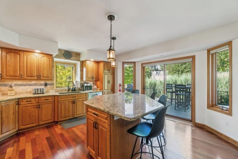 The large island kitchen opens up to upper back deck with BBQ and outdoor dining.