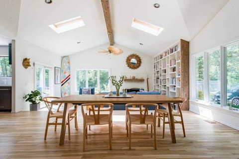 The vaulted ceiling of the great room has exposed beams and skylights showing the dinning and bar area to positive effect.