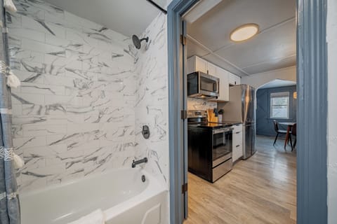 - Bright bathroom with modern tile shower and clean soaking tub for relaxing stays - Steps away from the updated kitchen offering seamless easy guest access - Fresh finishes create a welcoming space perfect for comfort and convenience