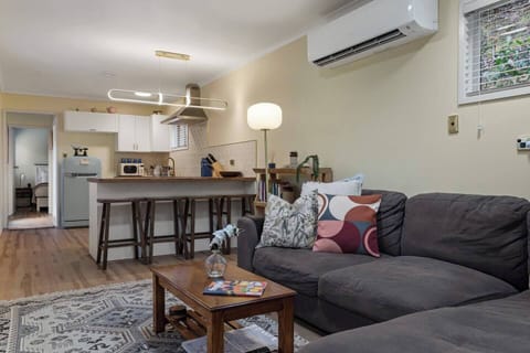 The living room is comfortable and cosy, with a long chaise lounge that sits under heating and cooling. Windows and ambient lighting keep the room bright and airy.
