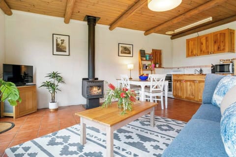 The open-plan living area features comfortable seating, a coffee table, and a TV, perfect for unwinding after a day of exploring. 