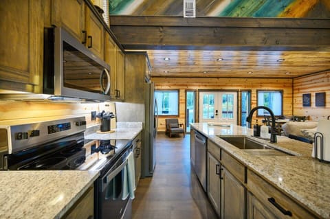 Modern meets rustic in this fully-equipped kitchen, featuring sleek granite countertops and stainless steel appliances. The open layout flows seamlessly into the living area, making it perfect for cooking and gathering with family or friends.