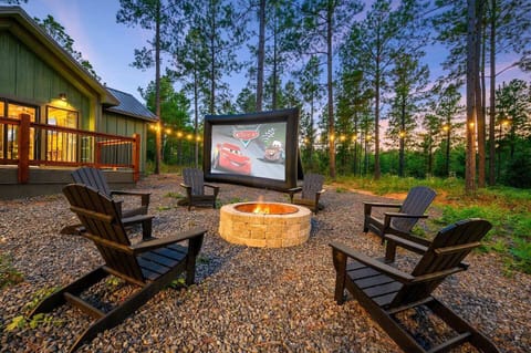 Cozy up by the outdoor fire pit surrounded by comfortable Adirondack chairs, perfect for stargazing or sharing stories under the night sky. Enjoy a magical movie night with the outdoor projector while string lights cast a warm, inviting glow throughout the backyard, creating the ultimate setting for evening relaxation.
