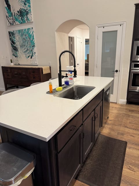 Main kitchen island with upgraded quartz and views into downstairs bedrooms
