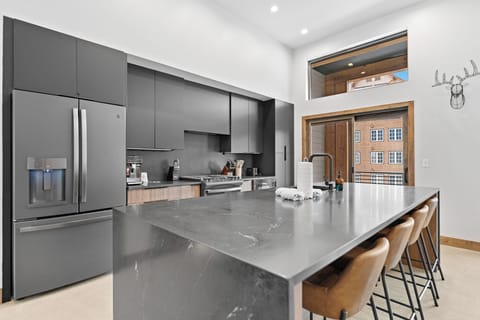 Full kitchen with stainless steel appliances, and breakfast bar seating 4.