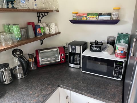 Toaster oven, microwave, variety of coffee makers and hot beverages.