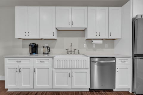 Bright, minimalist kitchen featuring sleek white cabinets &  modern appliances