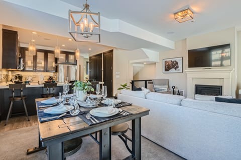 This modern open-concept living space features a fully equipped kitchen with sleek cabinetry and a spacious dining island—the perfect hub for shared mountain meals and social gatherings.
