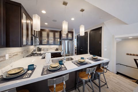 This modern open-concept living space features a fully equipped kitchen with sleek cabinetry and a spacious dining island
