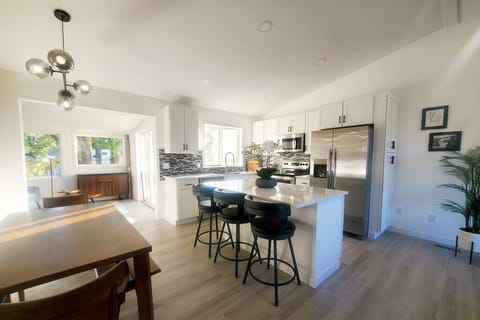 Fully stocked modern kitchen and 6-7 person dining table plus barstools