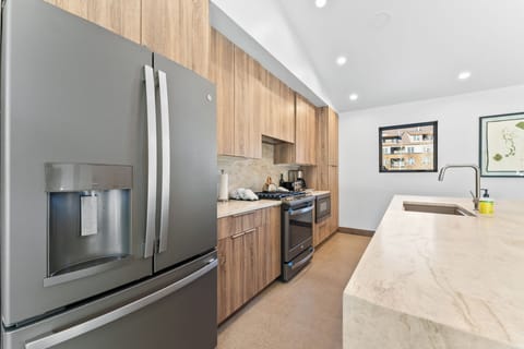 Full kitchen with stainless steel appliances, and breakfast bar seating 4.