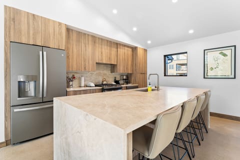 Full kitchen with stainless steel appliances, and breakfast bar seating 4.