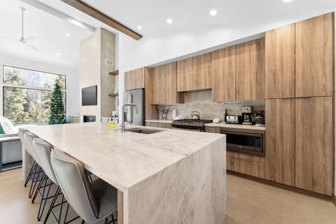 Full kitchen with stainless steel appliances, and breakfast bar seating 4.