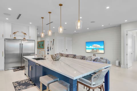 Kitchen equipped with induction stovetop, microwave, oven, refrigerator/freezer.