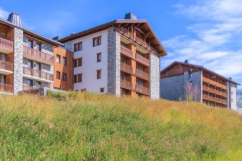 Surrounded by vibrant green meadows, this mountain retreat invites you to unwind and soak in the peaceful summer landscape.