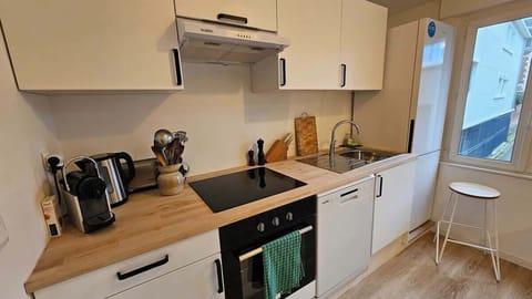 Cuisine équipée avec lave-vaisselle, four, plaques de cuisson, machine à café, bouilloire, grille-pain, micro-ondes et réfrigérateur avec congélateur.
Espace repas pour 5 personnes séparant la cuisine du salon.