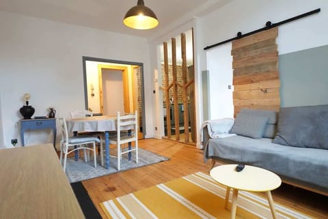 Salon avec télévision, salle à manger et cuisine semi ouverte.