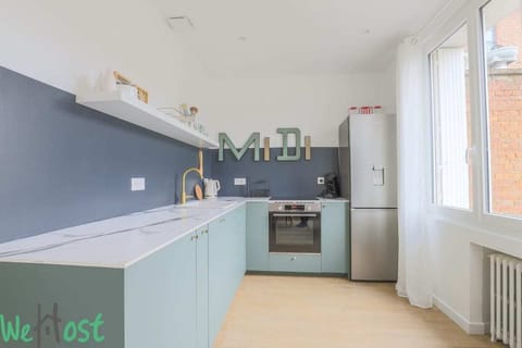 Cuisine équipée avec four, plaques de cuisson, machine à café, bouilloire, réfrigérateur avec partie congélateur, lave-vaisselle, machine à laver et micro-ondes.