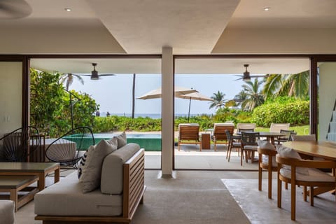 Enjoy indoor-outdoor living with this beautifully designed lounge space, complete with a cozy sectional and ocean views.
