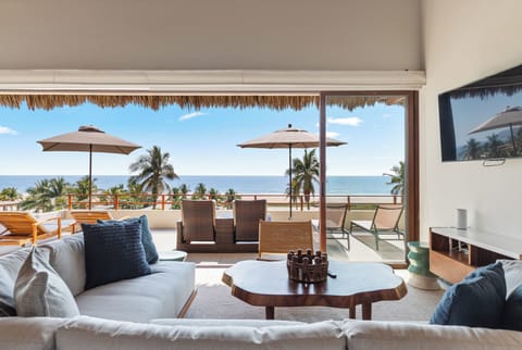 Relax in this elegant lounge space that opens to the terrace, where the view of palm trees and ocean blue is just beyond your seat.