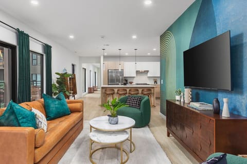 Open living room & kitchen space with beautiful windows leading out to the private corner patio, great for entertaining! Smart TV and Queen-size pull-out couch in the living room.