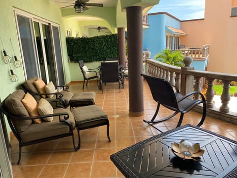 Spacious covered patio with cozy seating and dining area with sea view