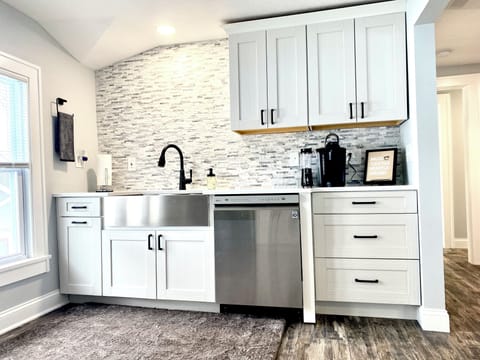 Keurig station with Starbucks coffee, stocked dishes, dishwasher for easy cleanup, and supplies belo