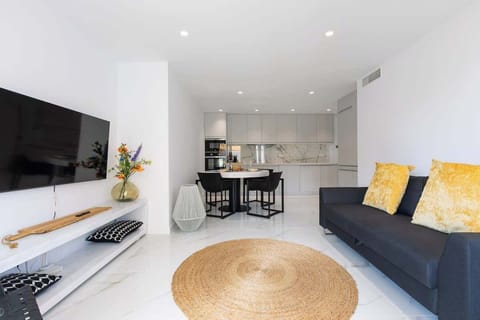 Open plan kitchen and living room. Fully equipped kitchen, comfortable sitting lounge with large glass doors leading to terrace which overlooks Marbella port and the beach.