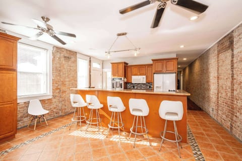 The kitchen showcases exposed brick, ample space, & numerous amenities