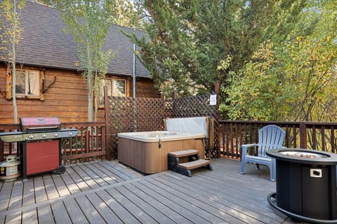 Deck featuring a firepit, hot tub and gas propane BBQ.