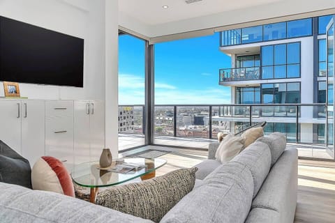 Relax in this stylish living room, complete with large TV and access to the balcony with stunning city views.
