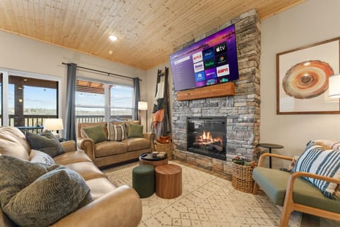 Relax in the comfortable living room with smart TV and stone electric fireplace