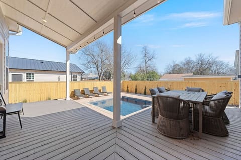 Back porch with outdoor dining area overlooking the pool