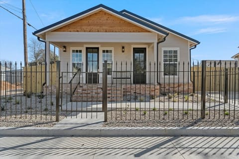 Exterior of the Gloria Cottage in a fully fenced yard. The driveway is not fenced.