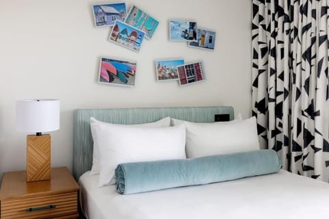 Sink into plush pillows beside bold curtains and coastal art.