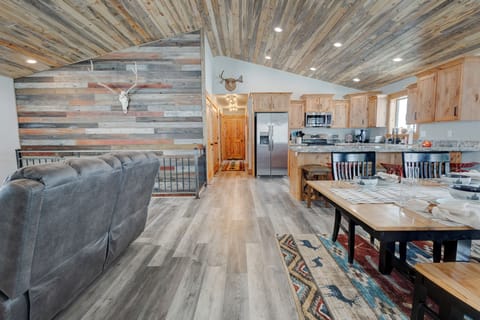 Vaulted great room with rustic finishes connecting living, dining, and kitchen.