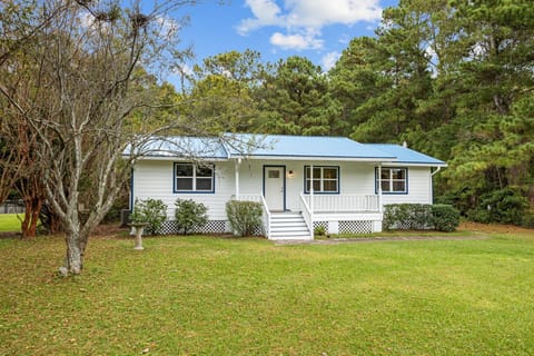 Charming bungalow with a spacious front porch and striking blue metal roof.