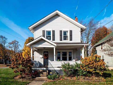 Classic two-story home w/ covered front porch, tidy landscaping & welcoming steps leading to the front door.