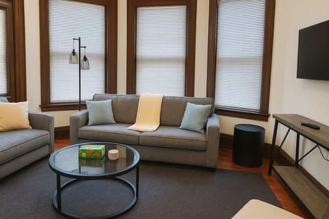 Inviting living area w/ sofa, coffee table & tall windows