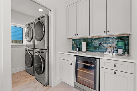 Double stack washer/dryer combo and beverage center with coffee bar and beverage cooler.