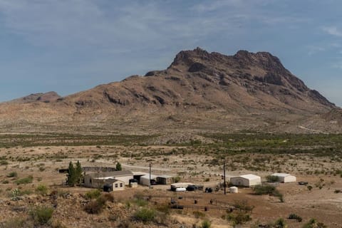 Ranch Compound with main Ranch House, three carports (one used for gatherings), game shack, wildlife feed paddock, East Corazones Peak in background