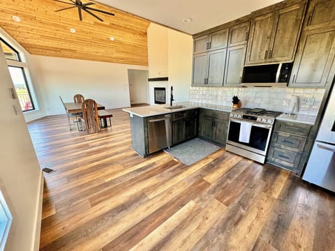 Kitchen with modern appliances, spacious counters, and bar seating.