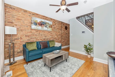 Living room with original exposed brick walls and original hardwood floors. 